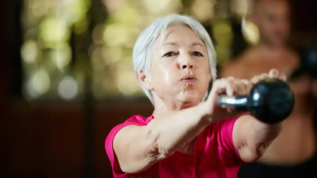 Toning Arms After 60: Empowering Womens Fitness Through Effective Weight Training 1 Older woman doing weight training Nottingham to help her strength and longevity
