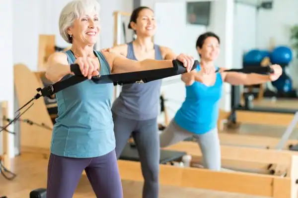 Toning Arms After 60: Empowering Womens Fitness Through Effective Weight Training 2 older woman doing weight training Nottingham and resistance in the gym to tone upper arms
