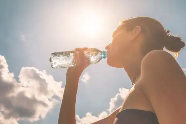 Hydration: The Secret Ingredient for a Toned Stomach and Enhanced Fitness 3 Image of woman drinking water to hydrate Nottingham after run.