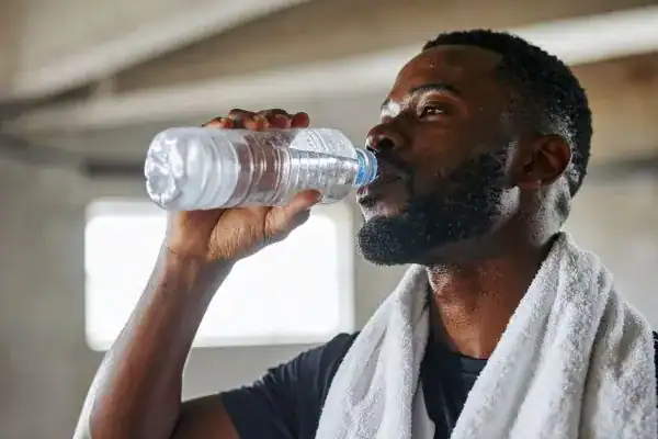 Hydration: The Secret Ingredient for a Toned Stomach and Enhanced Fitness 1 Image of man drinking water to improve hydration Nottingham after work out.